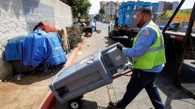 Edwin González de United Site Services coloca un lavabo de dos secciones en el centro para jornaleros Neil Good en la calle 17 en el centro de San Diego. (Eduardo Contreras / San Diego Union-Tribune)